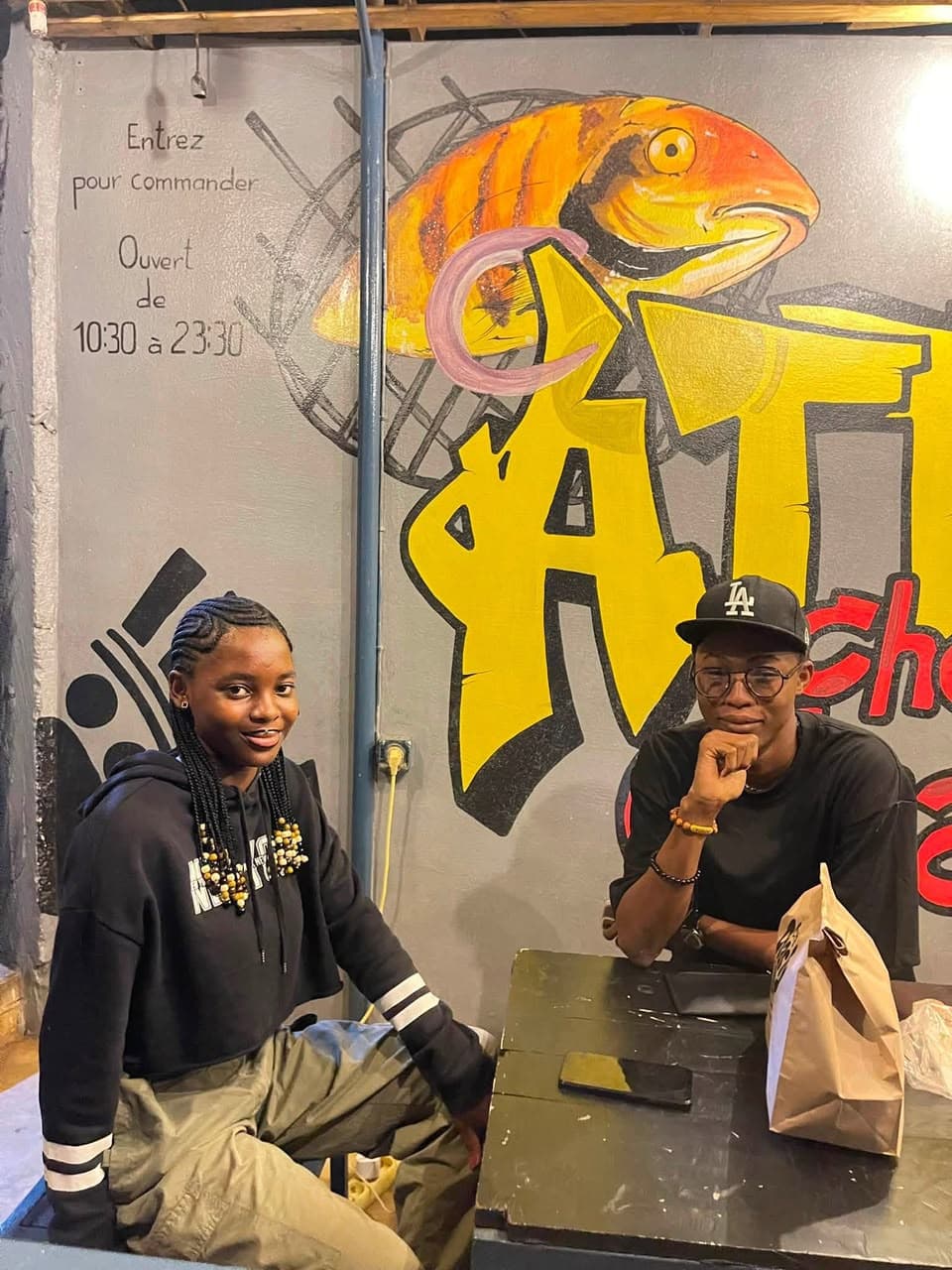 Clients Chez Charly devant la fresque murale